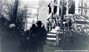 An outdoor speech taking place with British flags on display, [Alberta]