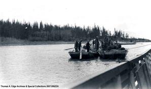 Three scows traveling down a river with men and supplies onboard. Two of the scows are tied together, [Alberta].