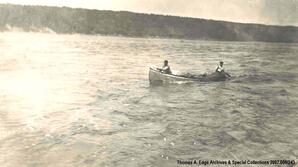 Two men traveling down a fast body of water in a canoe, [Alberta].