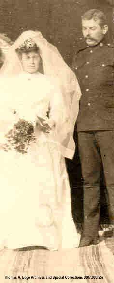 Portrait of a bride and a groom, she is wearing a traditional bridal gown and he is in a uniform, [Alberta].