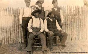 Portrait of five Indian men, three standing and two seated, [Alberta]. Note on the back reads: "Local Metis".