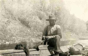 Man in boat with dead porcupine, [Alberta]. Note on the back reads: "Alex"