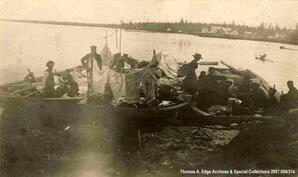 Three boats landed. The boats are full of people, supplies, clothing etc., [Alberta].