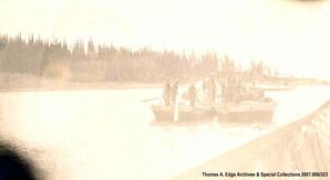 Three scows traveling down a river with men and supplies onboard, two of the scows are tied together, [Alberta]. Note on the back reads: ""Mr. Bill and his outfit on the way to Smith; Fred""