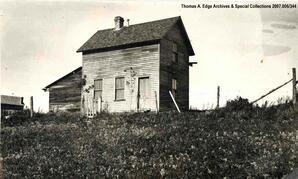 Three wooden buildings in a field, [Alberta]. Note on the back reads: "unknown".