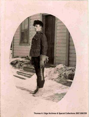 A portrait of a man out side of a building. He is in a uniform, [Alberta]. Note on the back reads: ""June 1911"".