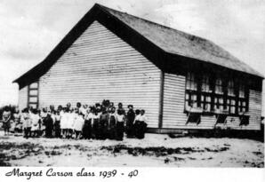 Students of Margaret Carson's class 1939-1940 (grades 1-4), at the original site of the Mission Hill School District No. 5685, Hollow Lake, Alberta.