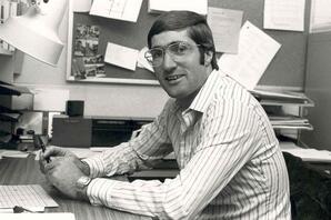 Dominique Abrioux, Director, Liberal Studies. Seated at a desk, Athabasca, Alberta