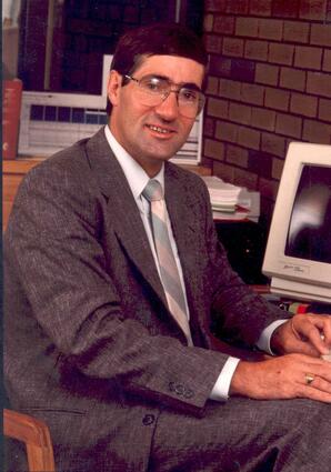 Dominique Abrioux seated at a desk, Athabasca, Alberta