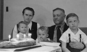 Poruks family around the traditional Latvian celebratory bread Klingeris